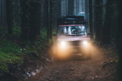 1991 red Range Rover Classic driving at night in the woods